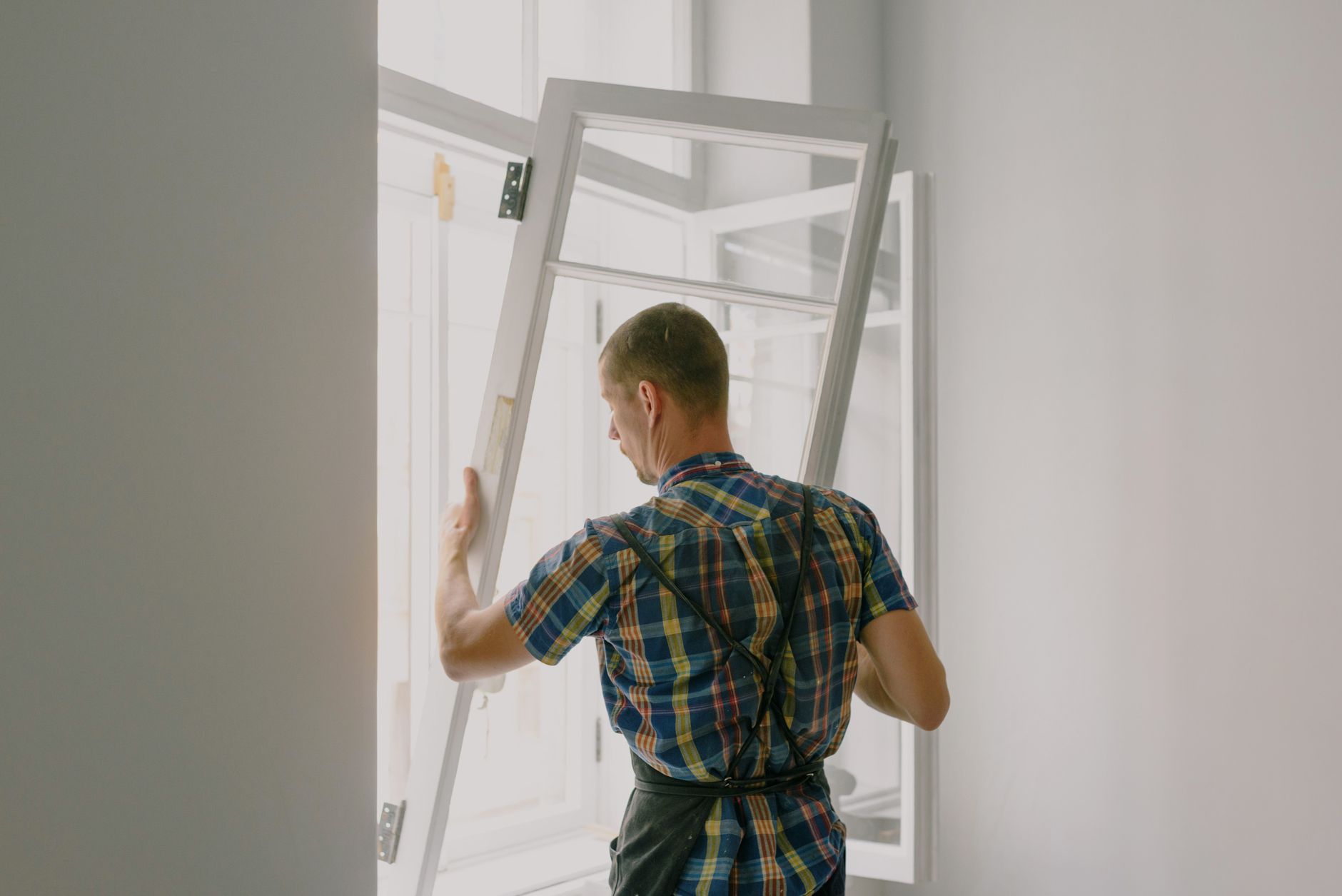 An installer mounting a new window frame inside a home