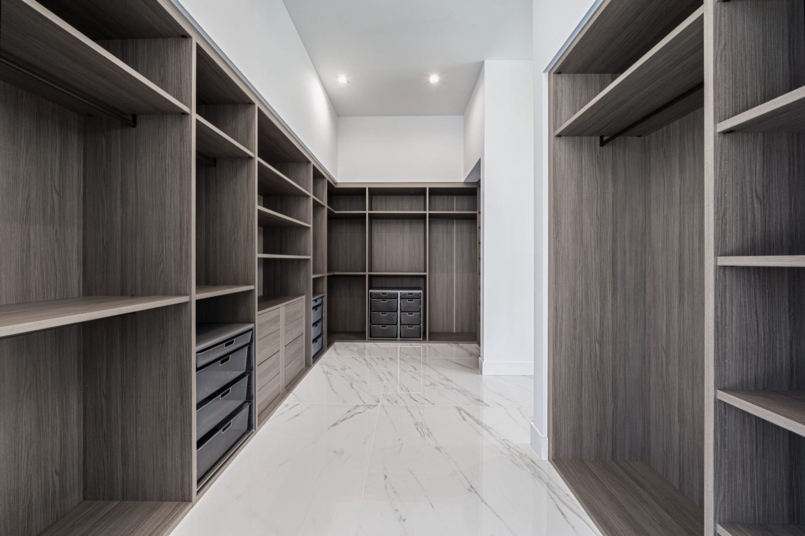 A custom walk-in closet with built-in shelving and drawers